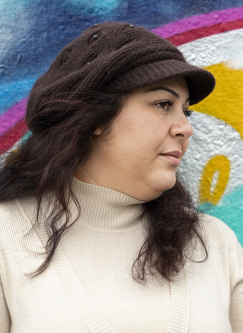 En kvinna står framför en grafittivägg